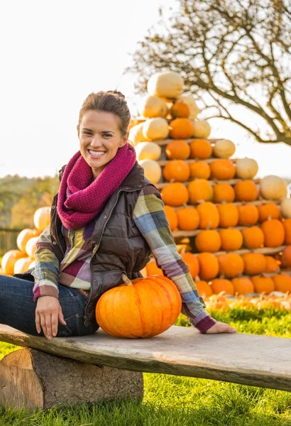 Портрет счастливой молодой женщины, сидящей с тыквой перед п — стоковое фото