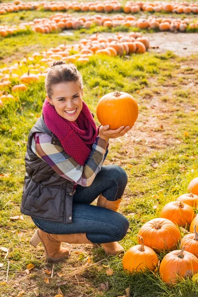 Retrato de una joven feliz mostrando calabaza — Foto de Stock