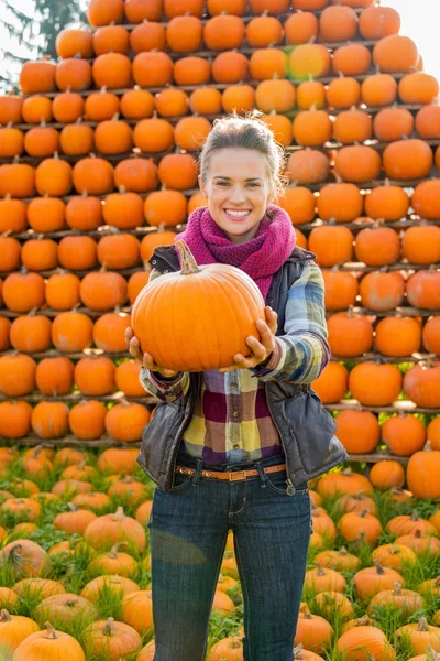 Portrait de jeune femme souriante tenant citrouille — Photo