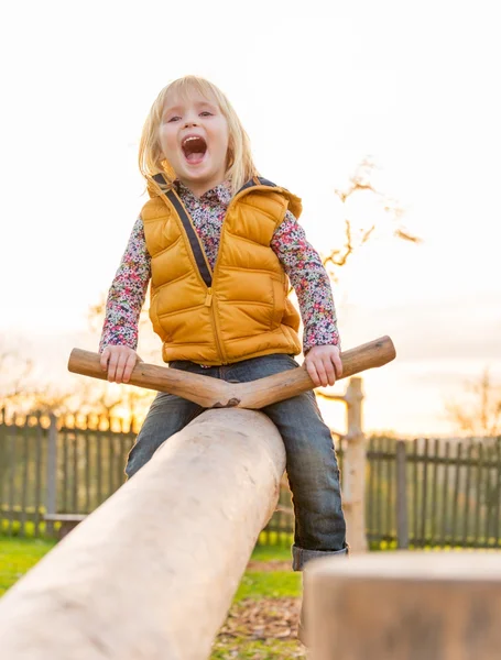 Porträt eines glücklichen Kindes, das im Freien schwingt — Stockfoto