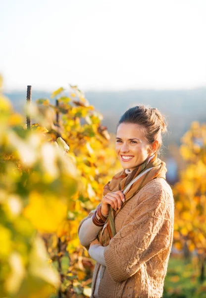Портрет счастливой молодой женщины, стоящей в осеннем винограднике — стоковое фото