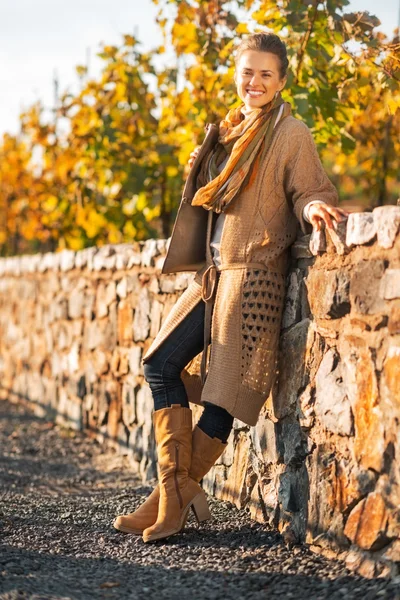 Full length portrait of smiling young woman in autumn park — Stock Photo, Image