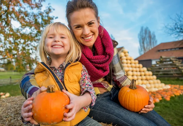 Portret van moeder en kind zittend op hooiberg met pu glimlachen — Stockfoto