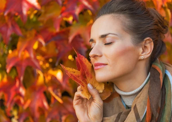 Portrait of relaxed young woman holding leash in front of foliag — Stock Photo, Image