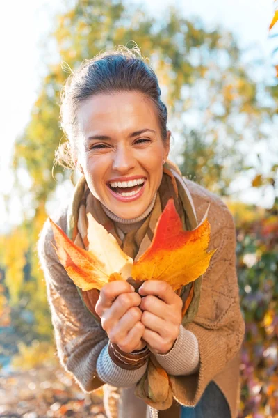 Portrait of happy young woman with autumn leafs outdoors — Stock Photo, Image