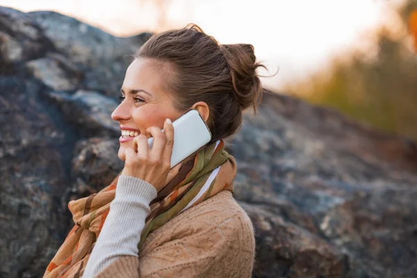 Szczęśliwa młoda kobieta rozmowy telefon komórkowy jesienią na zewnątrz w hotelowe — Zdjęcie stockowe