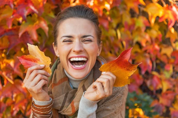 Retrato de jovem feliz com folhas na frente da folhagem — Fotografia de Stock