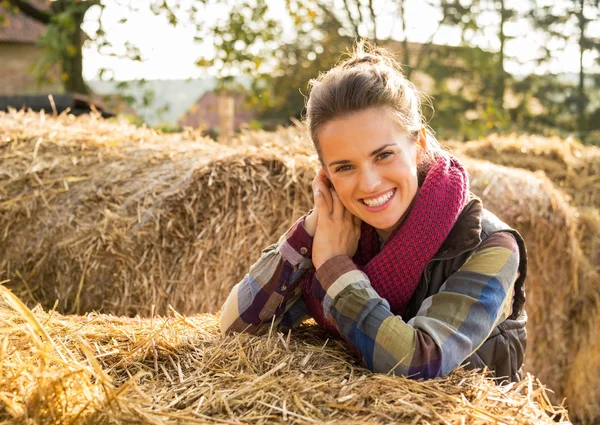 微笑的年轻女子，在干草堆里附近的肖像 图库图片