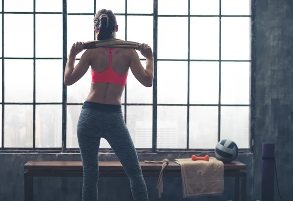 Vista trasera de la mujer en forma sosteniendo la toalla sobre los hombros en el gimnasio — Foto de Stock