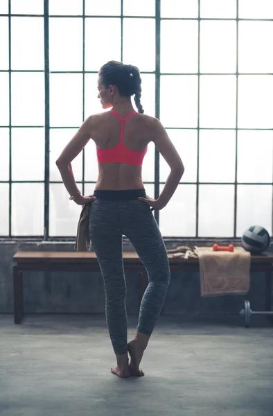 Rear view of woman in workout gear standing with hands on hips — Stock Fotó