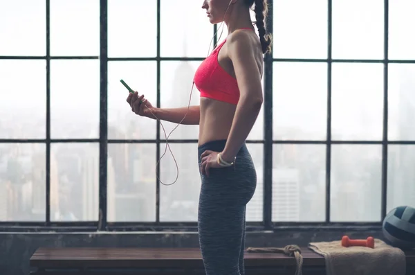 Partial view of woman looking down at device wearing headphones — 스톡 사진