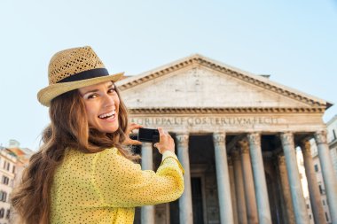 Smiling woman tourist taking photo of Pantheon in Rome