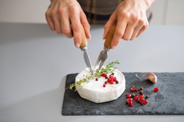 Kadının elleri Camembert kesmek için peynir bıçak ve çatal kullanarak