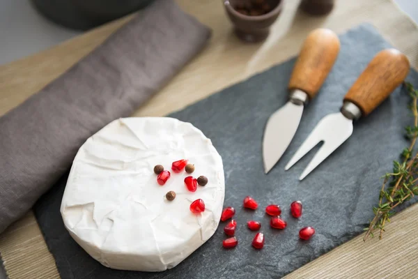 Fresh Camembert cheese on a slate with pomegranate seeds — ストック写真