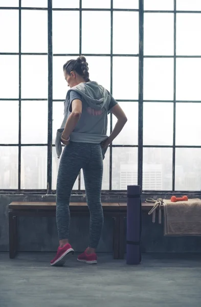 Rear view of woman in workout gear in city loft gym — 스톡 사진