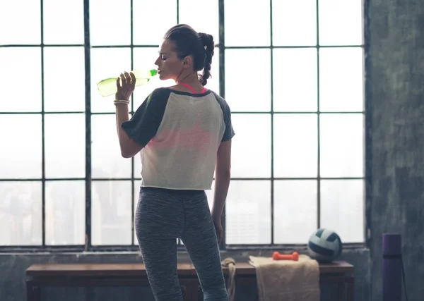 Fit woman in workout gear in profile drinking from water bottle — Φωτογραφία Αρχείου