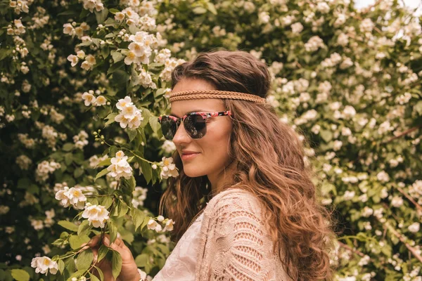 Profile portrait of happy hippie young woman among flowers — Stock Photo, Image