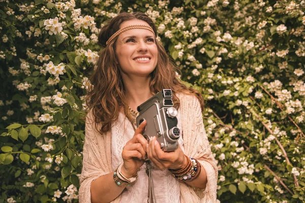 Boêmio jovem mulher com retro câmera olhando para cima no espaço de cópia — Fotografia de Stock