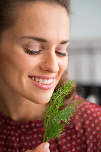 Closeup of smiling woman holding up and smelling fresh dill — Φωτογραφία Αρχείου