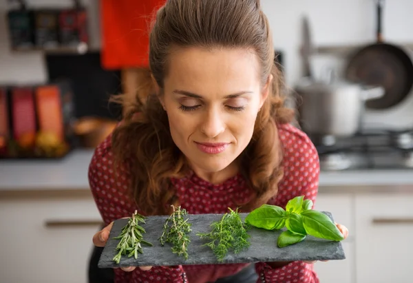 Woman with eyes closed smelling fresh herbs — Stockfoto