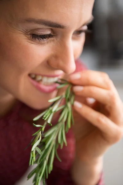 Primo piano di donna sorridente degustazione di rosmarino fresco — Foto Stock