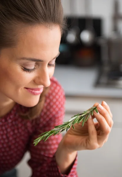 Smiling woman holding sprig of fresh rosemary in her hand — Stockfoto