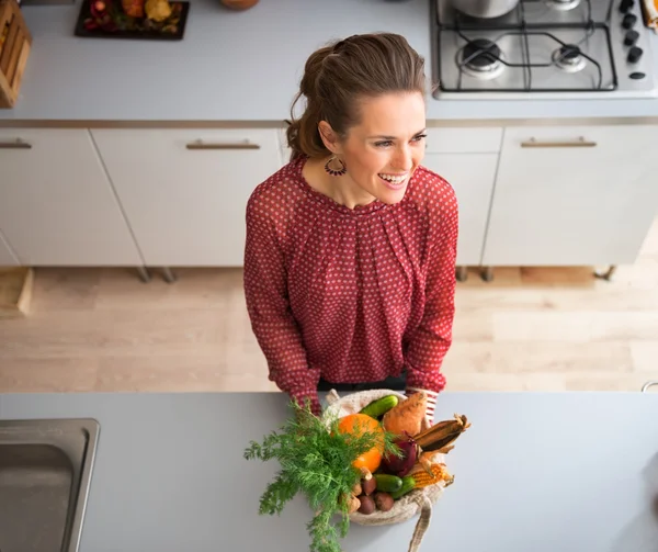 From above, smiling woman in kitchen with fall vegetables — Stockfoto