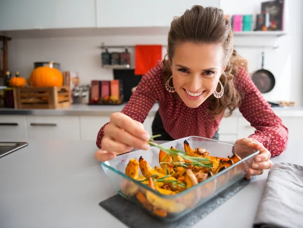 Smiling elegant woman preparing roasted pumpkin dish — Stock Photo, Image