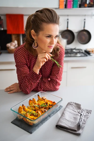 Mulher pensativa no balcão da cozinha com close-up de abóbora — Fotografia de Stock