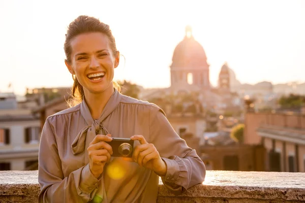 Смеющаяся элегантная женщина смотрит вверх от проверки фотографий в Риме — стоковое фото