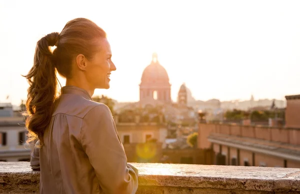 Elegante vrouw uitkijkend bij zonsondergang over de stad Rome — Stockfoto