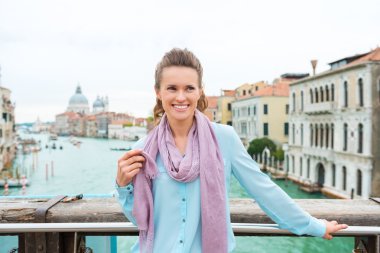 Smiling woman holding scarf standing on Bridge