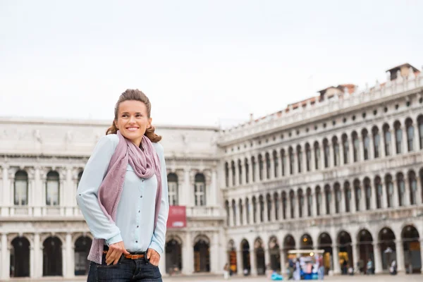 Happy woman tourist with hands in pockets on St. Mark's Square — Stockfoto