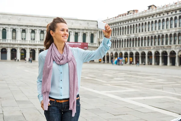 Happy woman holding device taking a photo while on St. Mark's — стокове фото