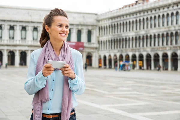 Woman looking up from her device while on St. Mark's Square — Stockfoto