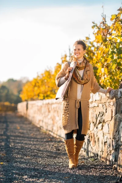 Mujer feliz en ropa cómoda está caminando en el parque de otoño — Foto de Stock