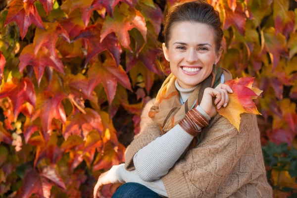 Portrét uvolněné ženy s podzimní listí před zeleň — Stock fotografie