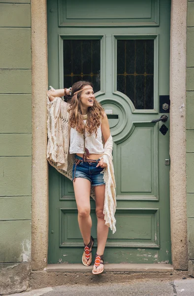 Glücklich Hippie aussehende Frau steht draußen vor Holztür — Stockfoto