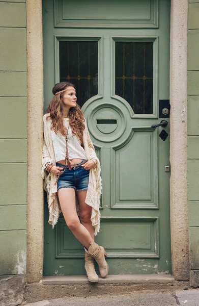 Mujer de aspecto hippy pensativa de pie al aire libre contra la puerta —  Fotos de Stock