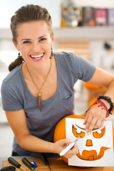 Boldog fiatal nő használata töltőtollak, faragni sütőtök Jack-O-Lantern — Stock Fotó