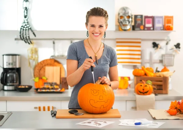 Mujer joven tallando una calabaza Jack-O-Lantern para la fiesta de Halloween —  Fotos de Stock