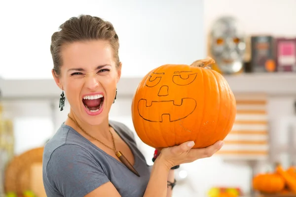 Молодая женщина, напуганная большой Хэллоуинской тыквой Джек-Фонарь — стоковое фото