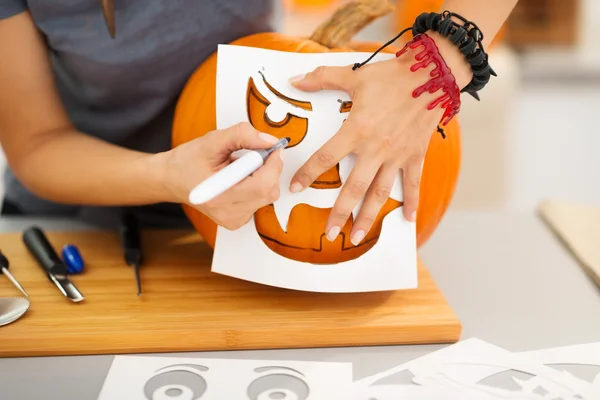 Vrouw met behulp van stencils te snijden pompoen Jack-O-Lantern. Closeup — Stockfoto