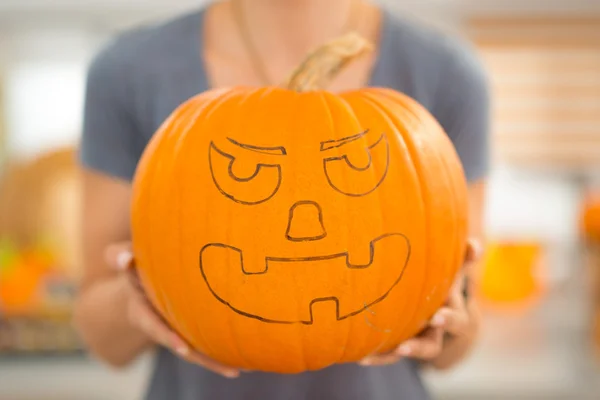 Close-up. grote enge Halloween pompoen Jack-O-Lantern in vrouw h — Stockfoto