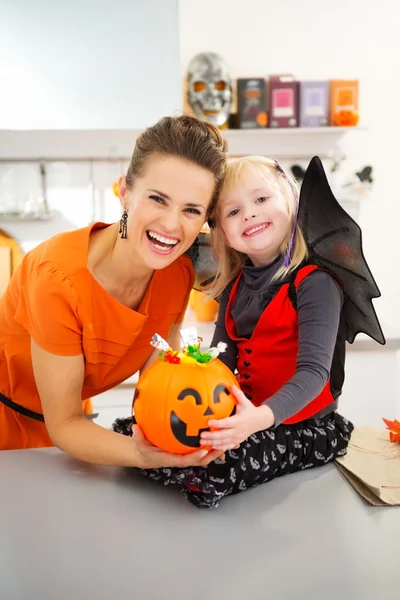 Портрет девушки, одетой в Хэллоуин, с матерью и конфетами — стоковое фото