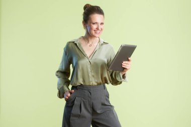 Gülümseyen bir kadın tabletiyle etkileşime girer, iş dünyasına bağlı özgüvenli, modern bir profesyoneli somutlaştırır..