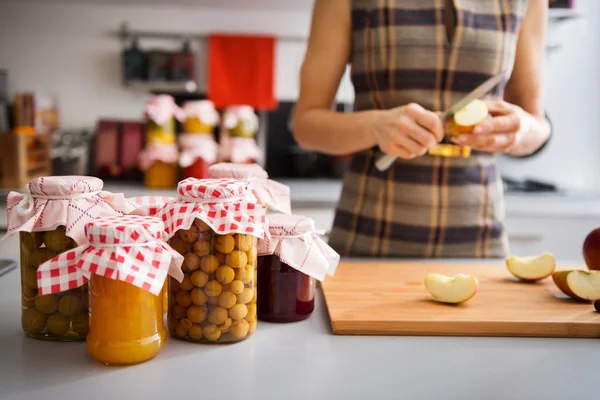 Geconserveerde vruchten in glazen potten met vrouw inkwartiering van apple — Stockfoto
