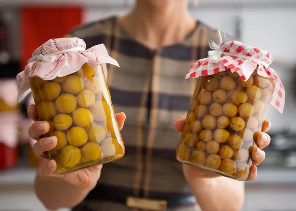 Closeup of yellow plums and gooseberries in glass jars — Stock Photo, Image