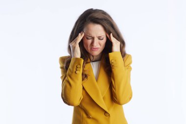 Hardal sarısı ceketli bir yönetici kadın, şakaklarını kapalı gözlerle tutar. Yoğun stres, baş ağrısı ya da iş ortamında profesyonel yorgunluk taşır..