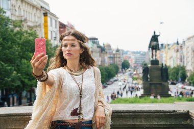 Trendy hippie woman making selfie on Wenceslas Square, Prague